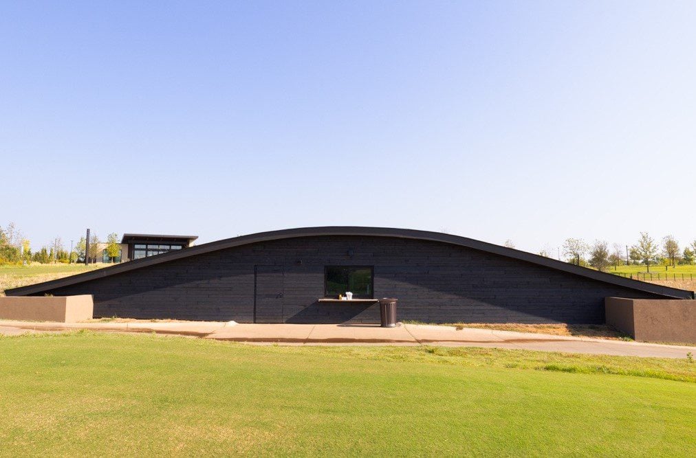 The exterior of The Bunker, a low-profile, curved concession building set against the golf course.