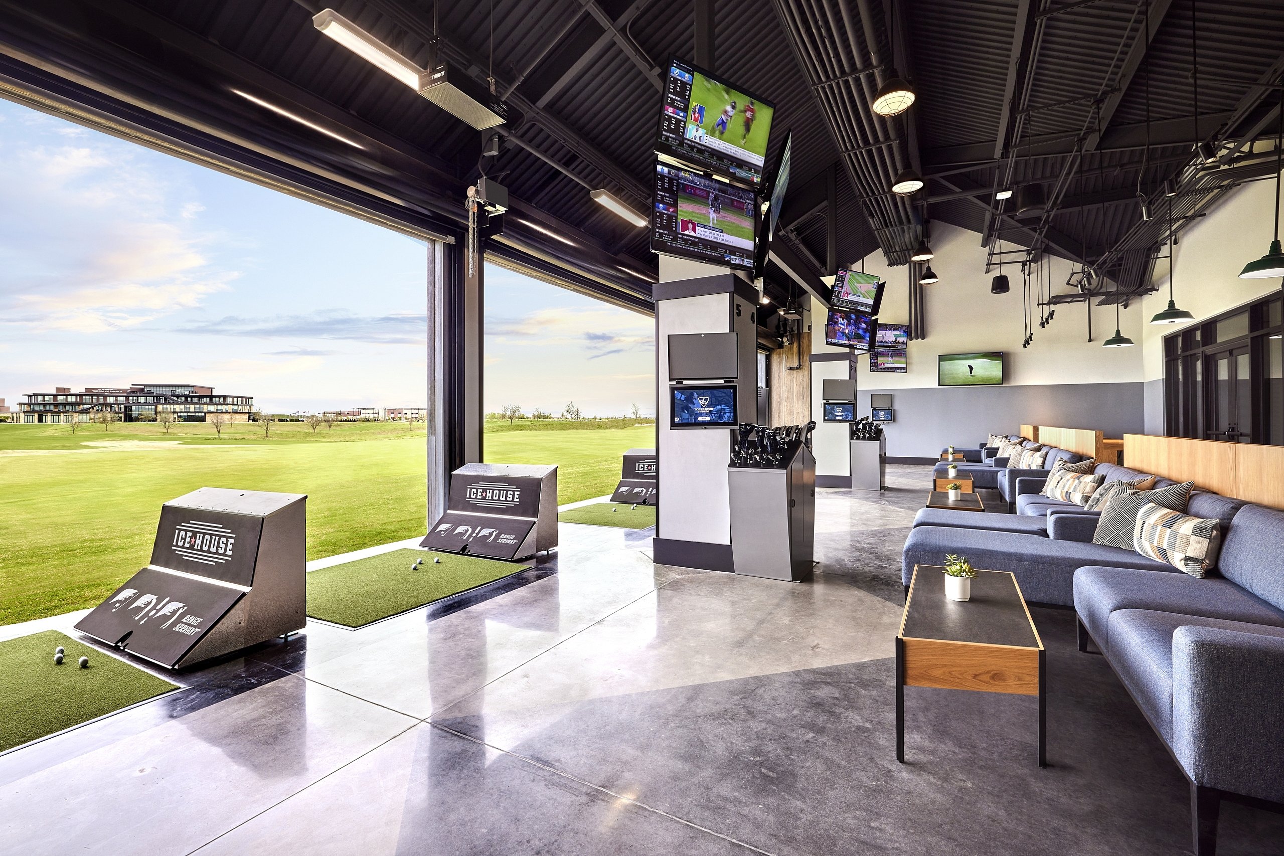 The Ice House indoor/outdoor golf range with hitting bays, lounge seating, and multiple TV screens.