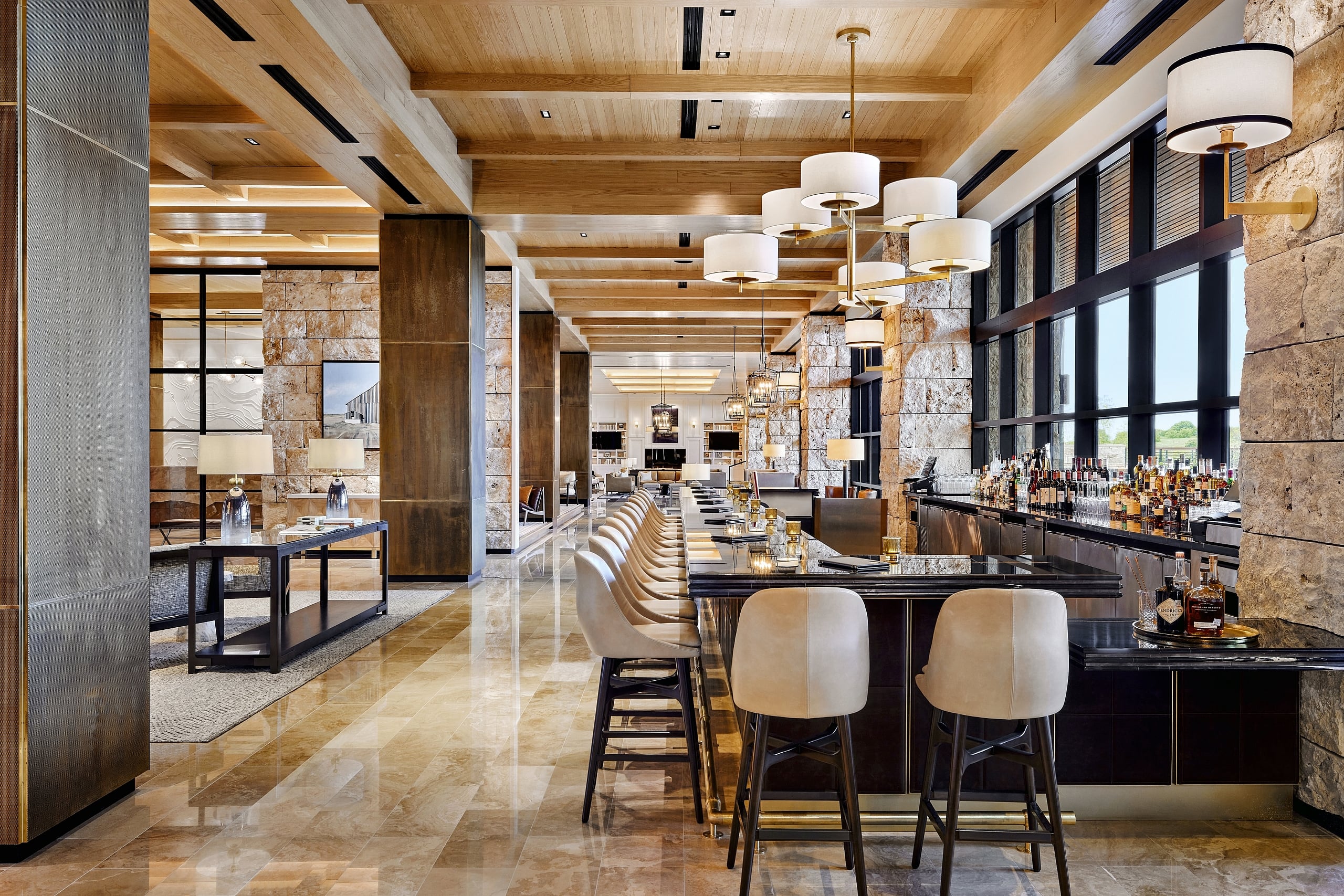 The elegant bar area of The Lookout Lounge featuring stone columns, high ceilings, and bar seating.