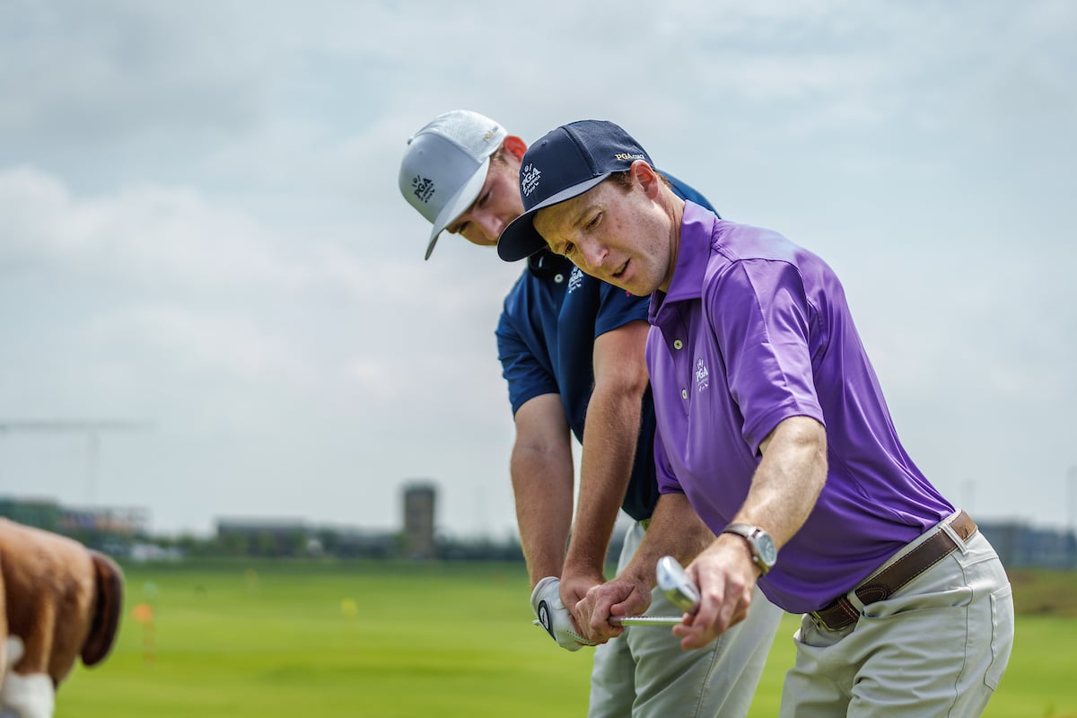 a golf coach guiding a student through their golf swing