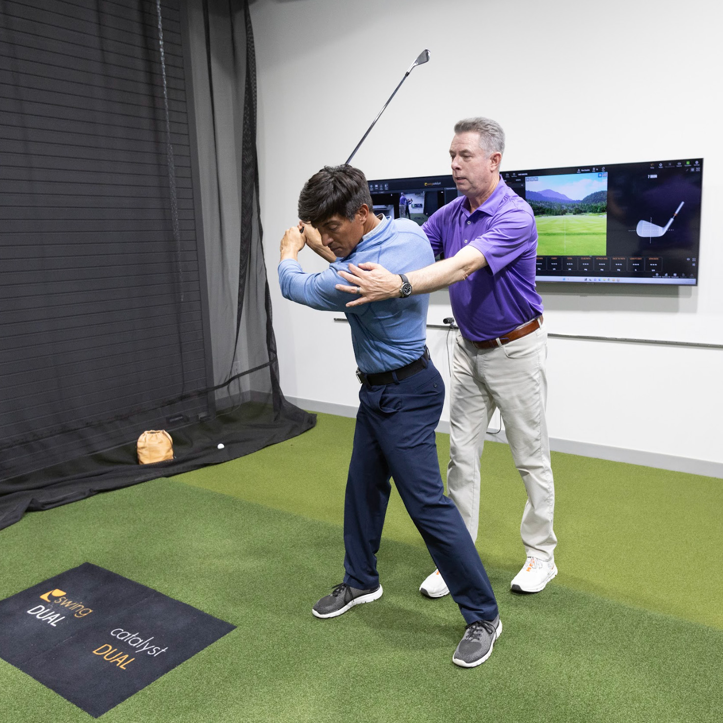 a golf instructor guiding an athlete through their golf swing