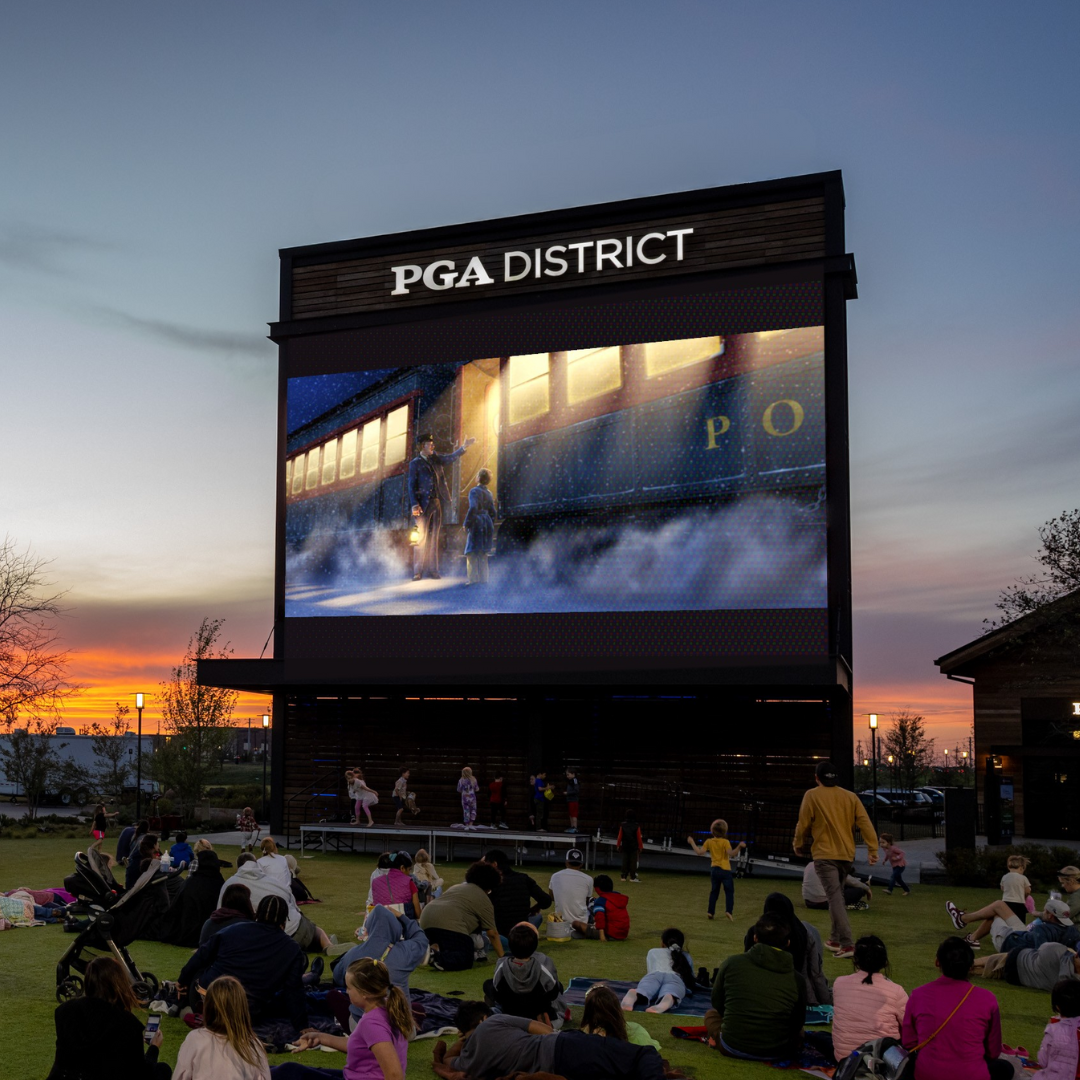 the PGA District screen displaying a movie as the sun sets in the background