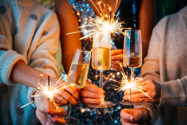 sparklers are lit behind champagne flutes