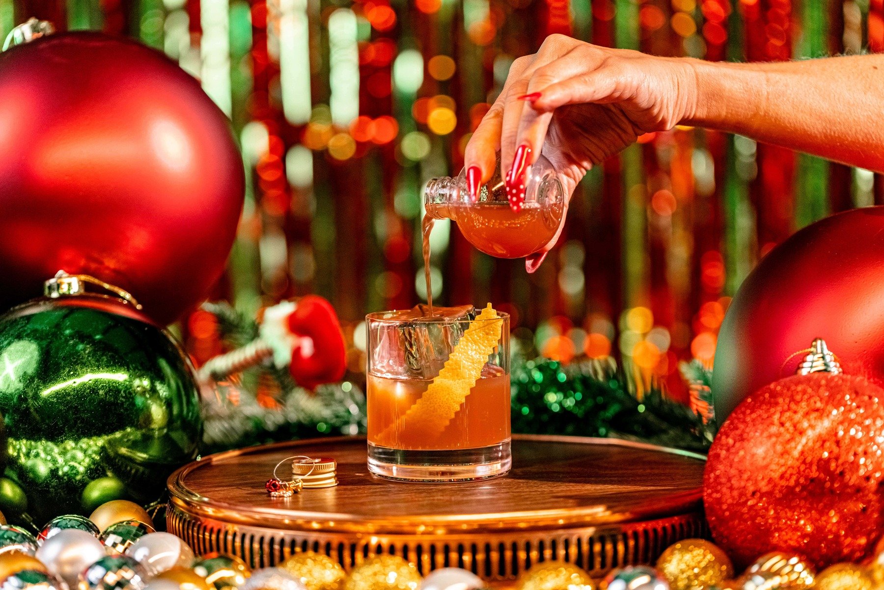 pouring a drink with a festive background