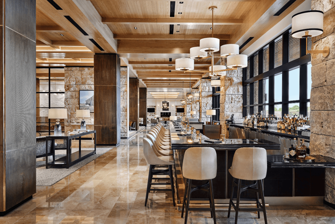 The elegant bar area of The Lookout Lounge featuring stone columns, high ceilings, and bar seating.