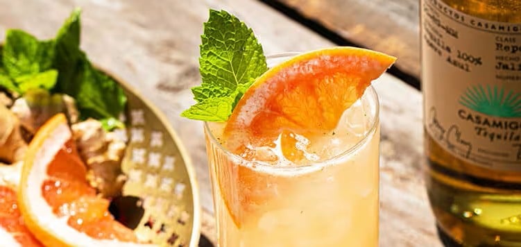Picture of an Orange mixed drink with orange and mint garnish