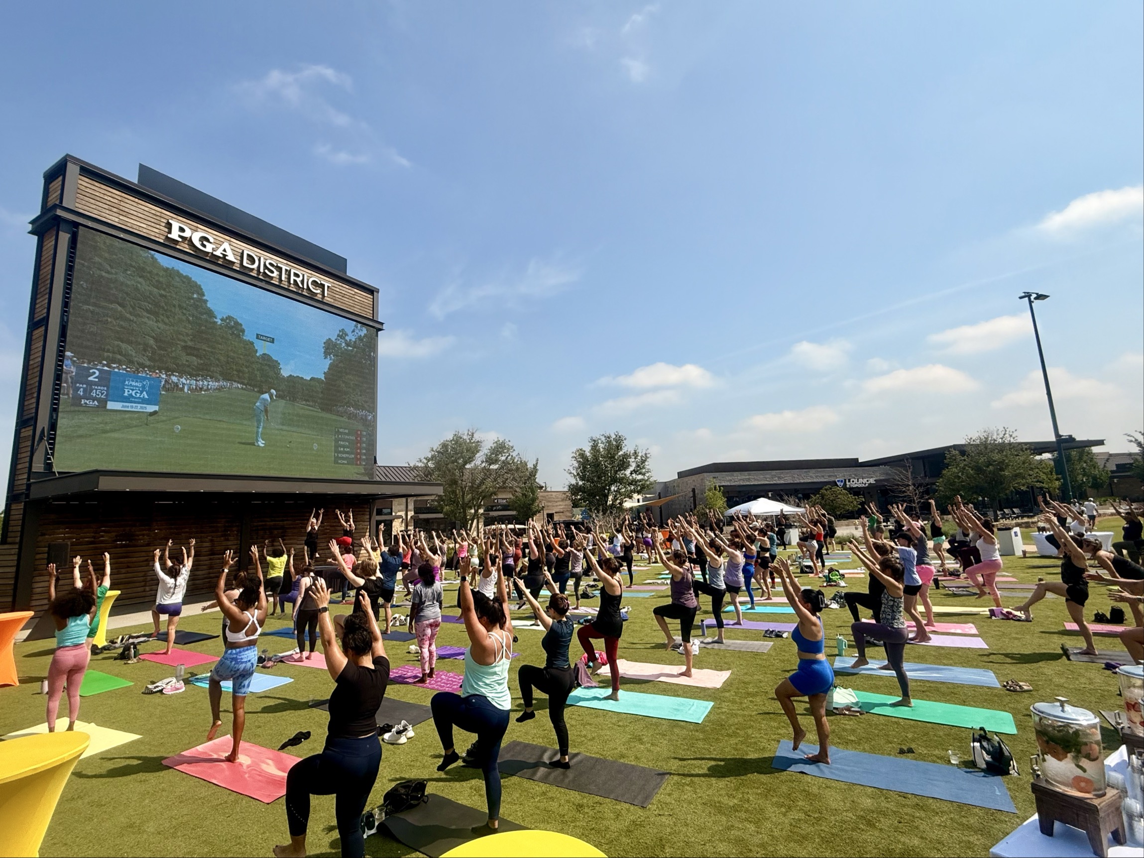 People outside on a lawn doing yoga